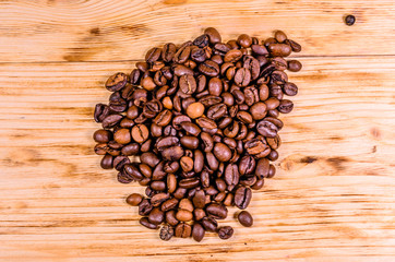 Pile of the roasted coffee beans on wooden table. Top view