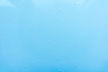 Drops, water splashes on blue background. Cute simple background, backdrop. Top view. Close-up. Stock photo