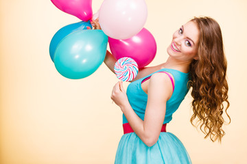 Woman with colorful balloons and lollipop