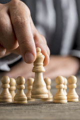 Man playing chess moving the queen piece