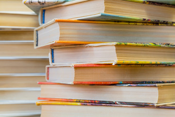 A stack of books in multicolored covers in the library or bookstore.