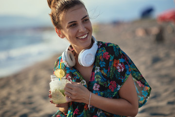 Young woman drinking cocktail on the beach