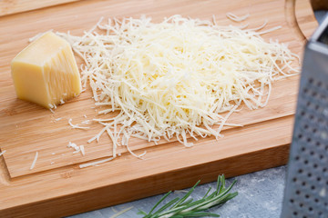 Grated parmesan cheese on a wooden board. Cooking food.