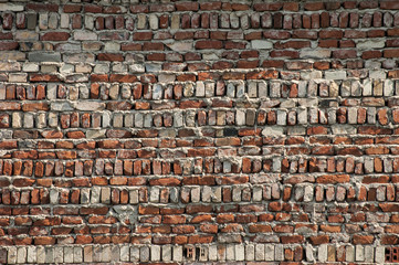 Old grunge crumbled non-plastered brick wall surface closeup as background