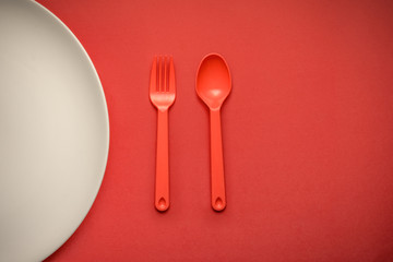 Red Fork/Spoon on red background with white plate.