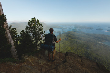 Man standing on the cliff with view on ocean and islands