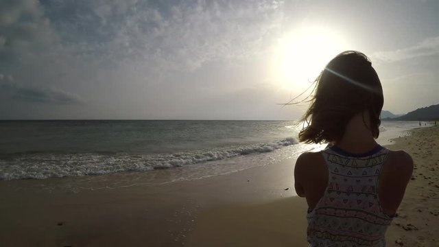 4K : Girl taking pictures with smart phone on the beach at sunset
