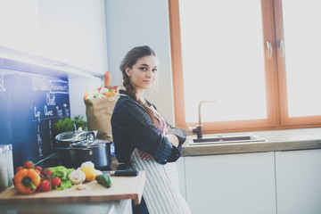 Young woman sitting on table in the kitchen.