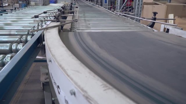 Packaging lines without boxes in warehouse. Automatic conveyor in delivery company.