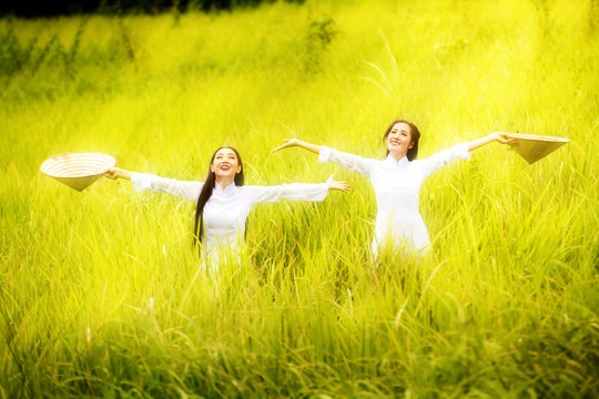 Vietnamese girl, standing in a meadow, a cheerful smiling happily.