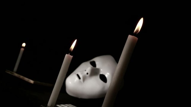 Burning candle fire and mystique mask
