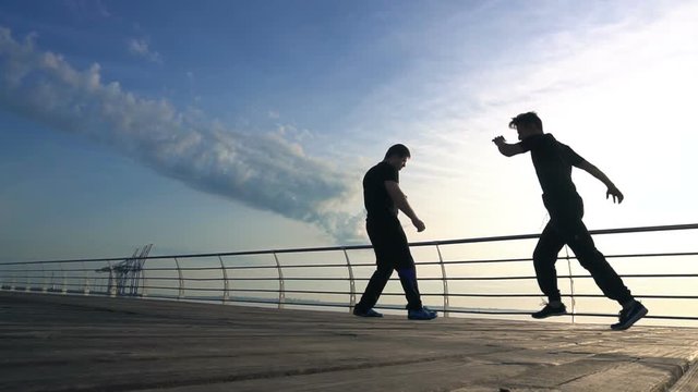 Young man fight training against sunrise in slow motion