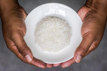 Rice and dish on both hands.