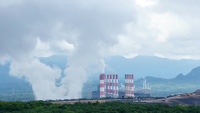 The atmosphere is tainted by air pollution as smoke and smog envelop the landscape, emanating from industrial activities, particularly a coal power plant in the morning mist
