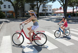 Young mum and little girl through the pedestrian strips with a b