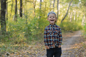 Naklejka na ściany i meble happy boy in autumn forest
