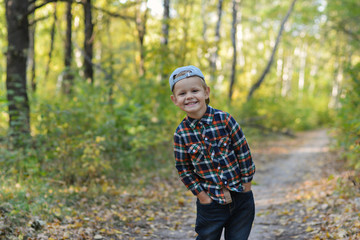Naklejka na ściany i meble happy boy in autumn forest