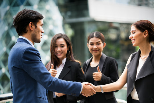  business man and woman shake hand with smile fac