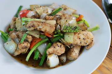 Close-up stir fried fish with black pepper in white plate
