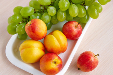 Peaches and grapes on a white plate