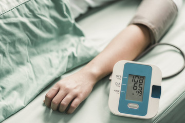 Doctor uses a blood pressure monitor patient.
