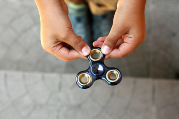 1238100 Hand spinner or fidgeting spinner rotating on child's hand