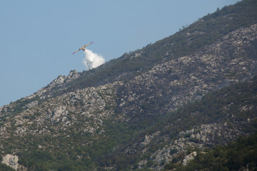 Fototapeta premium Airplane extinguishing the huge forest fires on the mountains close to Herceg Novi and the bay of Kotor in Montenegro 