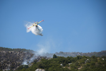 Fototapeta na wymiar Airplane extinguishing the huge forest fires on the mountains close to Herceg Novi and the bay of Kotor in Montenegro 