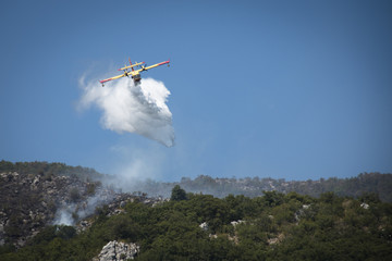 Fototapeta premium Airplane extinguishing the huge forest fires on the mountains close to Herceg Novi and the bay of Kotor in Montenegro 