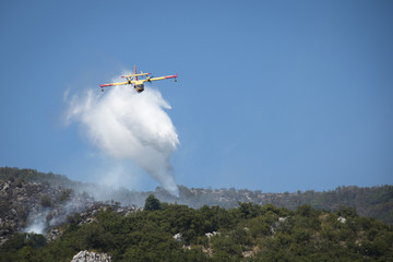 Fototapeta na wymiar Airplane extinguishing the huge forest fires on the mountains close to Herceg Novi and the bay of Kotor in Montenegro 