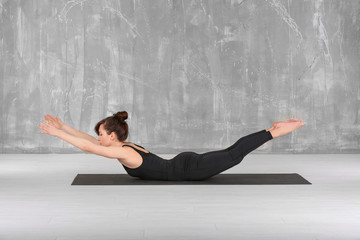 Young woman practicing yoga on floor