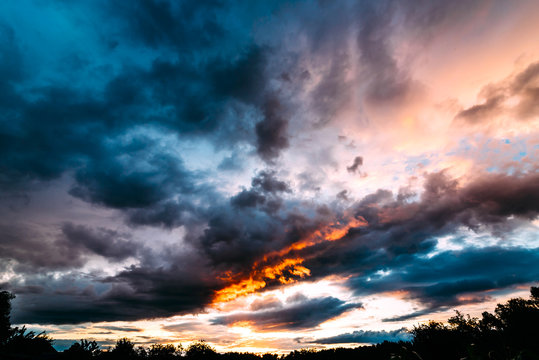 Dramatic gray, blue and orange sunset on beautiful sky, free space. Sky background on sunset with clouds