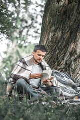 The young man at the tree reading a book