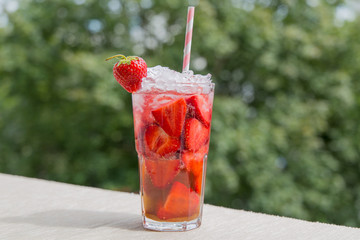  Cold strawberry mojito cocktail drink lemonade macro close-up with strawberry and ice 