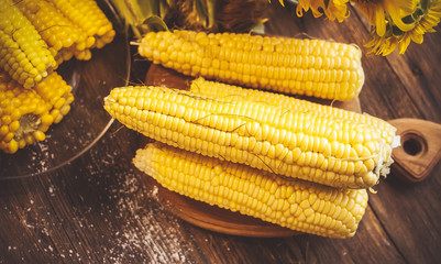 Hot corn with salt on a wooden table.