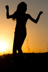 Silhouette of a girl with long hair at sunset