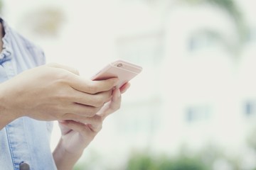 This image is a picture of a woman using a mobile phone with a house in the background. The concept is technology.