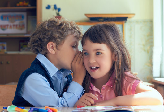 Pupils whispering secrets during class at the elementary school.