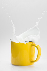 Yellow cup with fresh milk