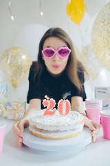 bautiful caucasian girl blowing candles on her cake