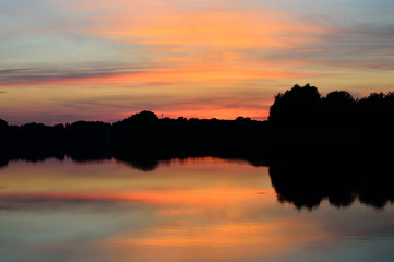 Zachód słońca nad jeziorem i odbicie w wodzie