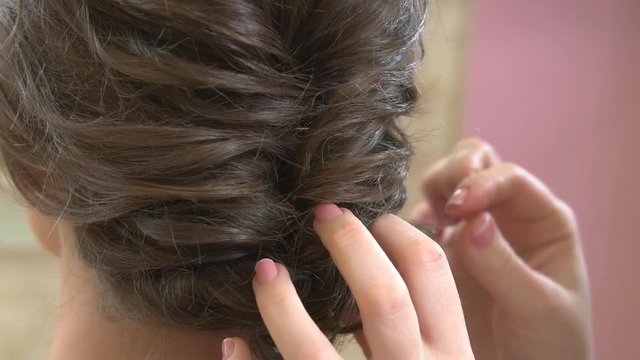 Braided female hairdo close up. Brown hair of woman.