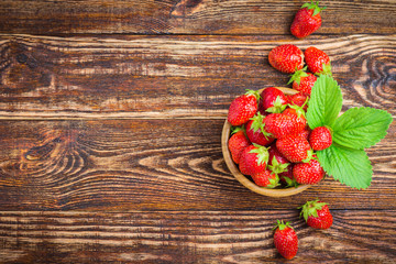  Fresh strawberry in a bowl on rustic wooden background.  Space for text.