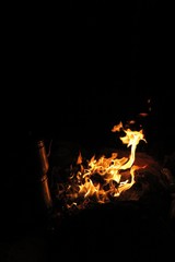 Campfire at night. Making tea in the teapot.