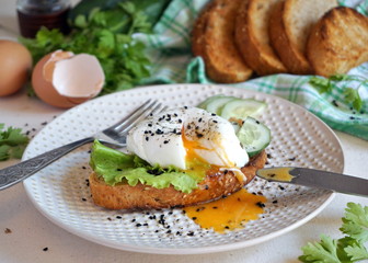 Egg poached on toast with lettuce and cucumber