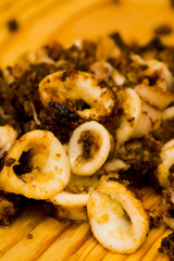Fried squids and shipirons  with lemon on a wooden plate