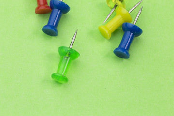 pins on green background. Colorful pushpins
