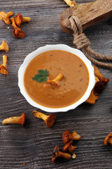 Mushroom cream soup with fresh chanterelles and herbs on a rusti