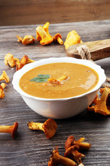 Mushroom cream soup with fresh chanterelles and herbs on a rusti