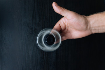 A hand with rolling spinner with black wooden background